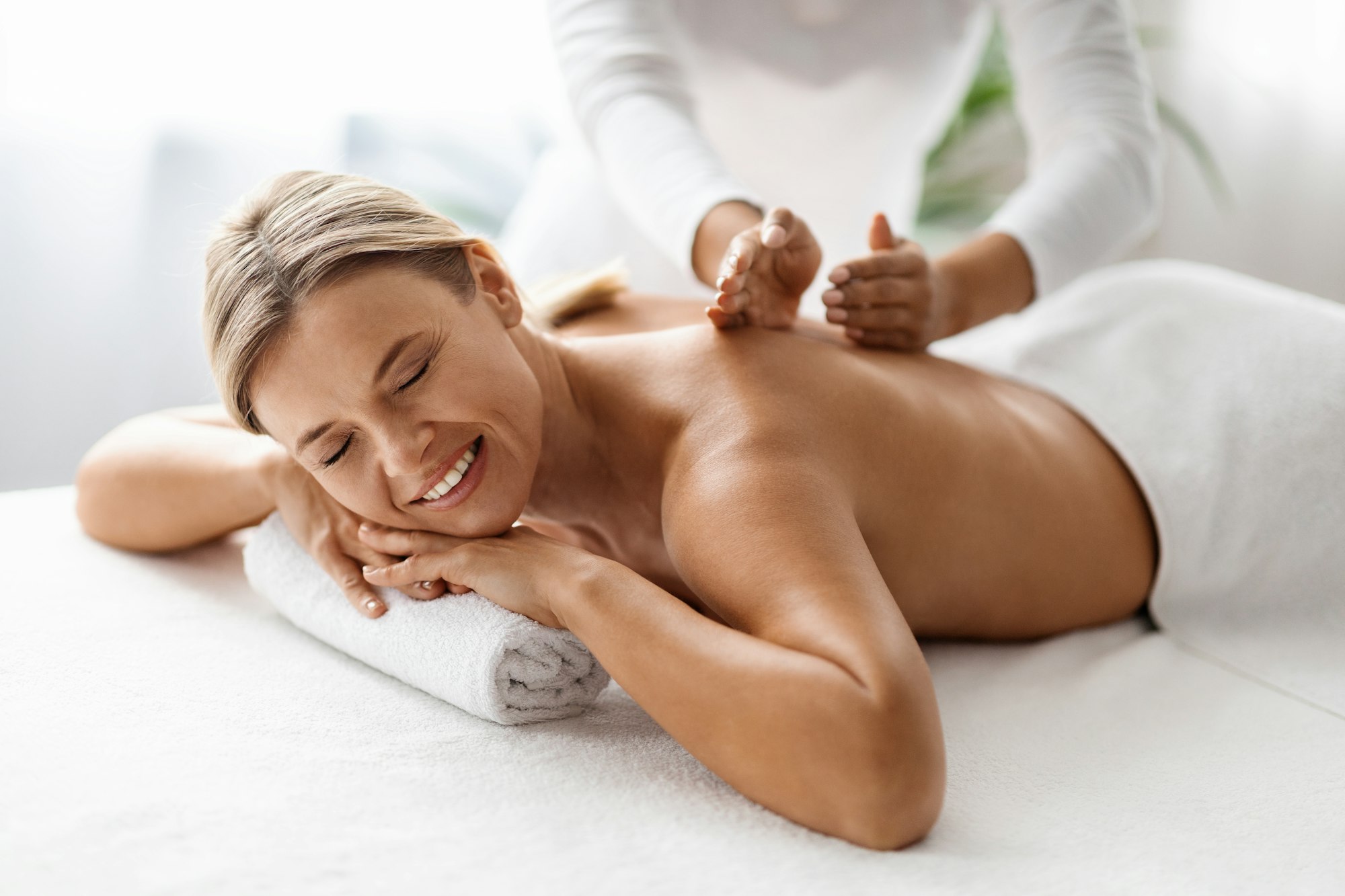 Beautiful Middle Aged Woman Enjoying Professional Wellness Massage In Spa Salon